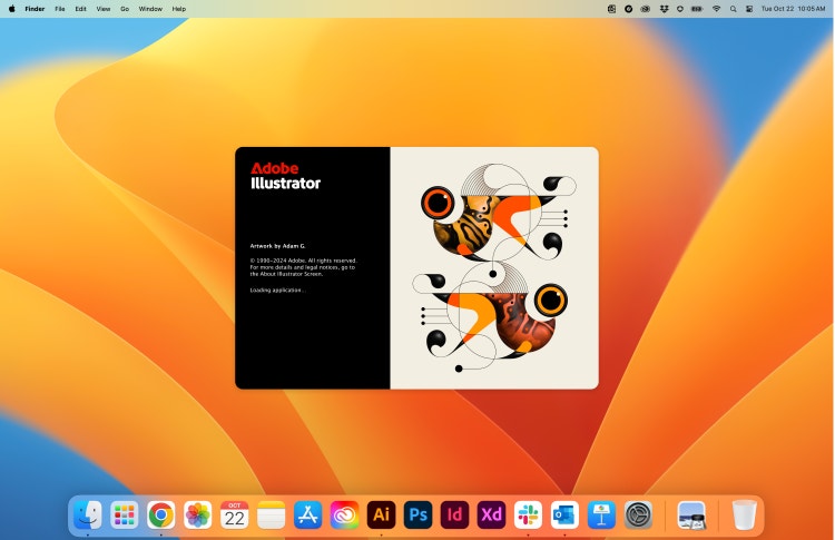 The latest Adobe Illustrator splash screen opening on a Mac desktop with a blue and orange background, a system menu bar at the top, and a dock with a row of application icons at the bottom. The left side of the splash screen is black with the heading "Adobe Illustrator." Under the product name it reads, "Artwork by Adam G, 1990-2024 Adobe. All rights reserved. For more details and legal notices go to the About Illustrator Screen. Loading application." On the right side are two very stylized goldfish (the top one facing left and the bottom one facing right) in swirling colors of orange, black, and tangerine on a tan background.
