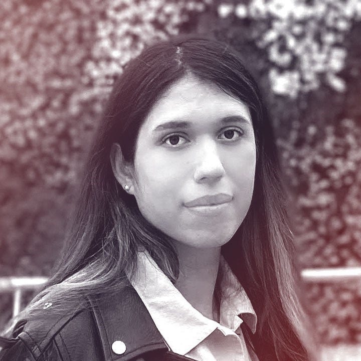 A photograhic profile portrait of a young non-binary person facing the camera.