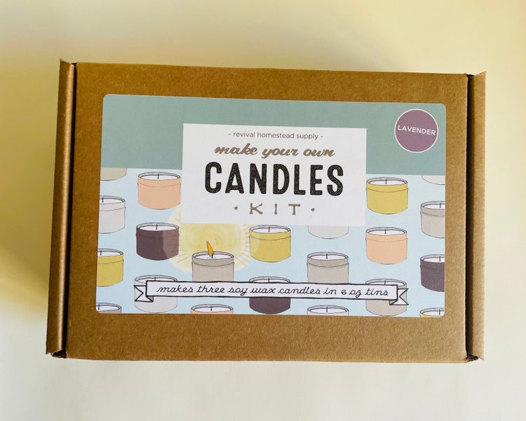 A carboard shipping box with a label decorated with candles in colored tins, reads "Make your own candles kit. Makes three soy wax candles in 6 oz tins."
