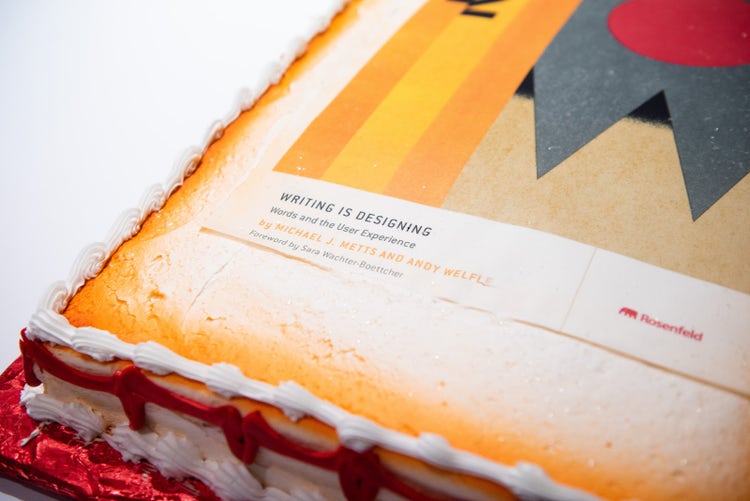 A photograph of a cake with the book cover of "Writing is Designing"