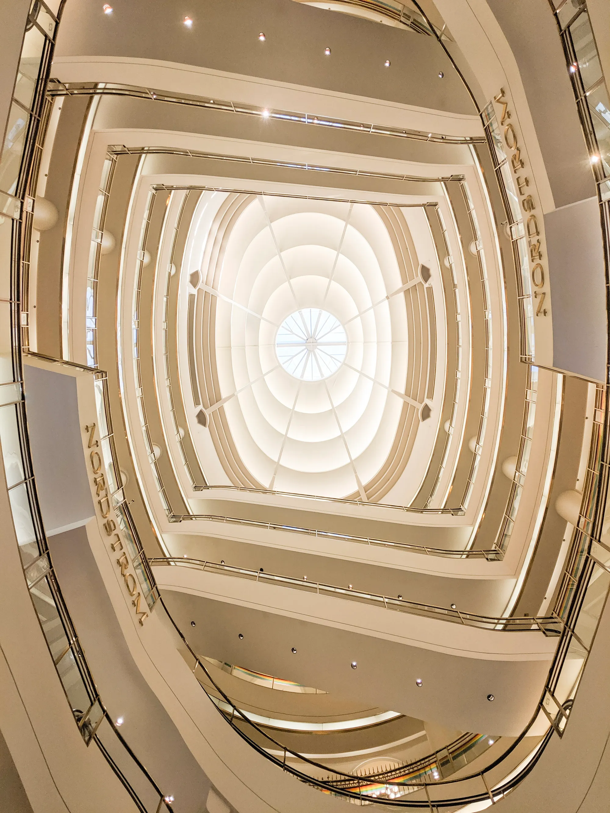 A photograph looking up at a domed ceiling through multiple stories of spiral walkways.