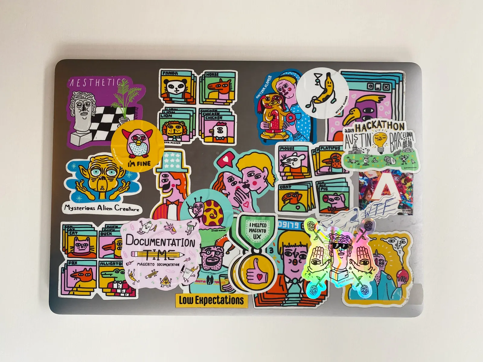 A closed laptop covered with multiple stickers.
